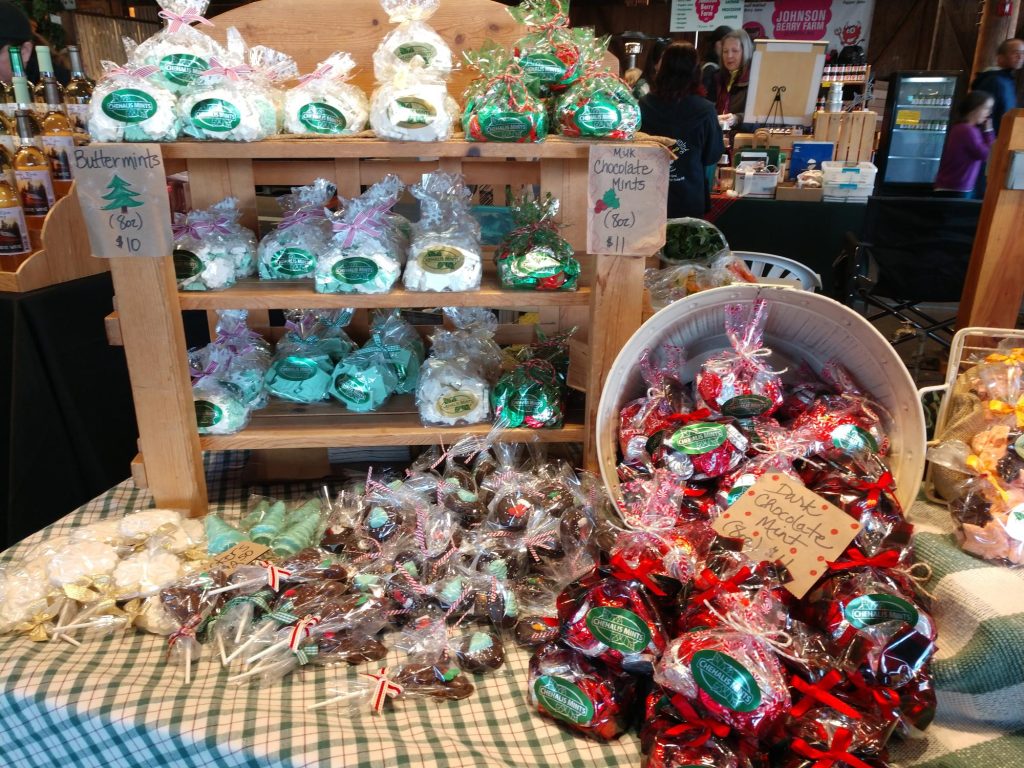 mints packaged in clear plastic on a table with a wooden display shelf and an overturned barrel