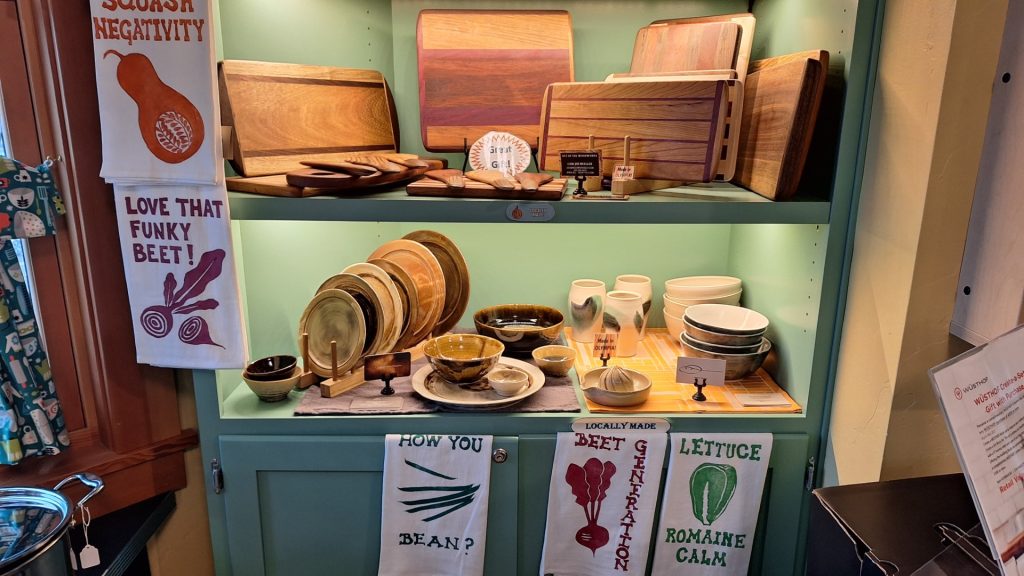 wooden cutting boards, plates and more on a hutch at The Rolling Pin