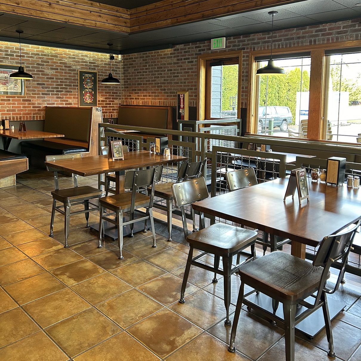 Brewery Pizza dining area with a bunch of empty wood tables with metal and wood chairs