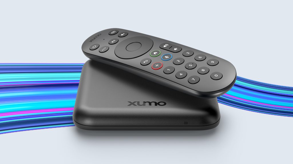 black streaming box with a black remote on top with blue lines in the background