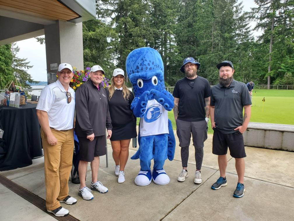 six people pose for a photo with the SPSCC mascot