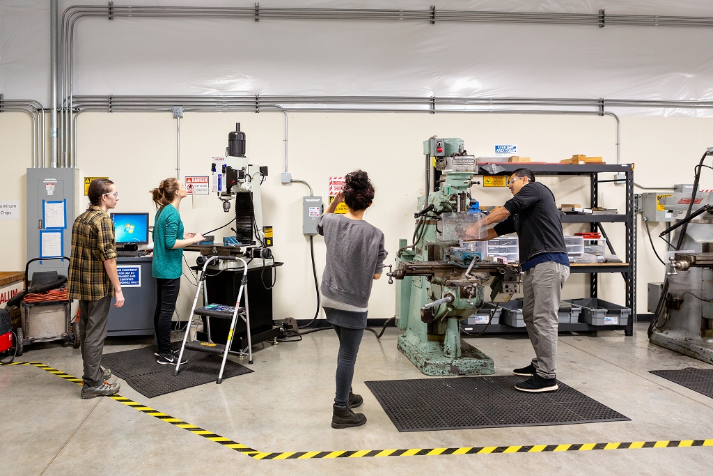 Four college students work on machines in the Saint Martin's University Civil Engineering department