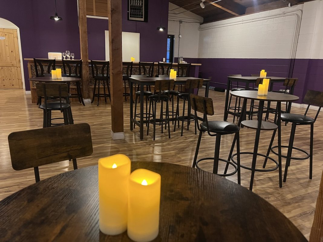 Inside Cup of Swords in Olympia with wood floors and high wooden tables and chairs.