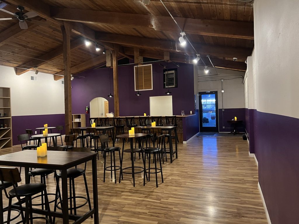 Inside Cup of Swords in Olympia with wood floors and high wooden tables and chairs.