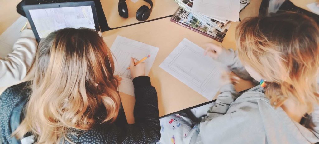 two people drawing out mural ideas at a desk