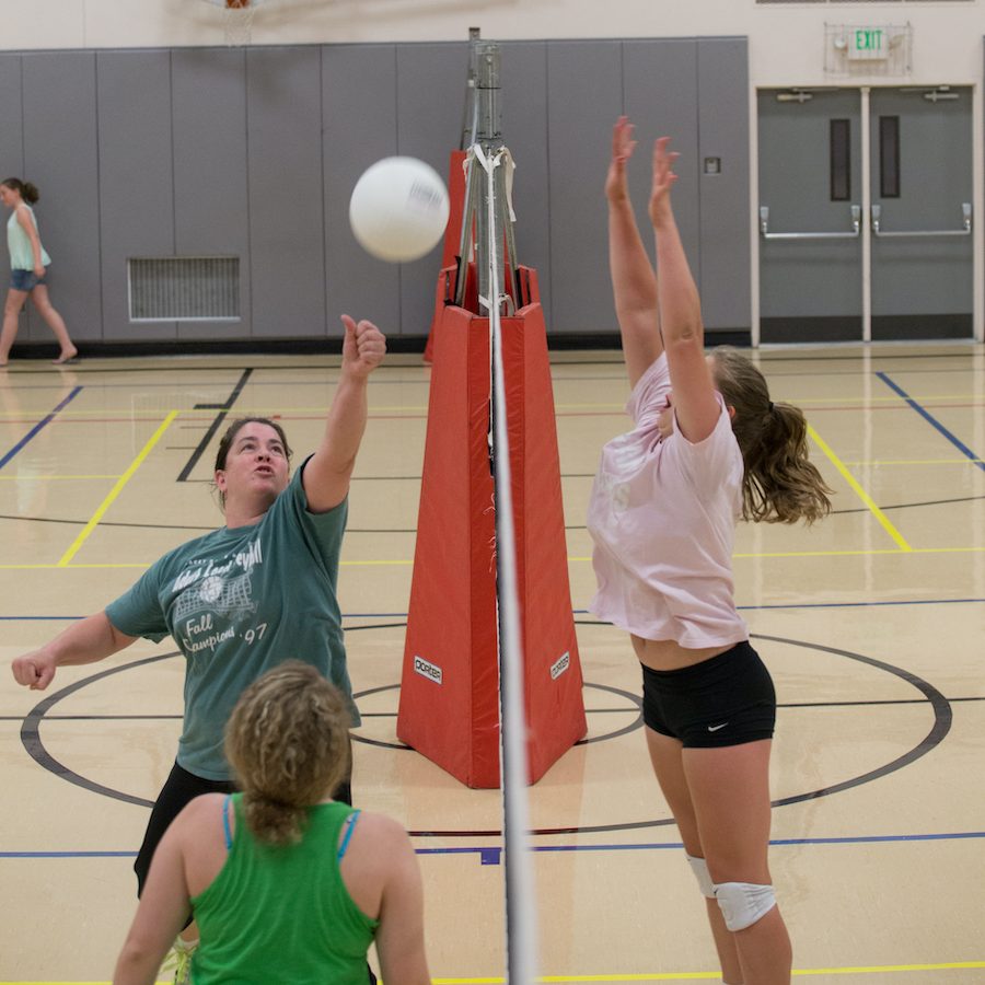 women playing volleyball on an indoor court