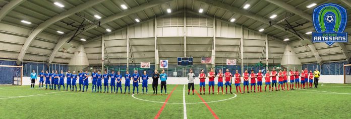 two soccer teams lined up on the turf inside The Evergreen State College pavilion