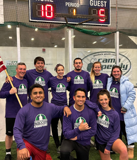 co-ed soccer team wearing 'soccer champion' shirts pose for a photo