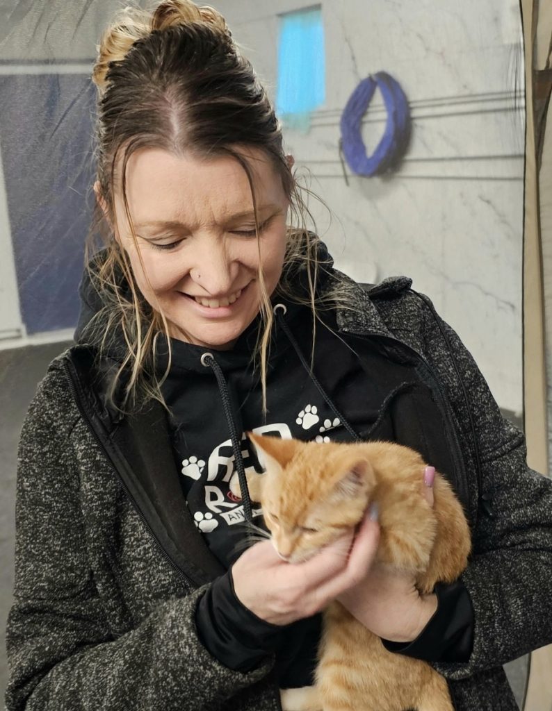 Tiffany Weitzel holding an orange tabby cat