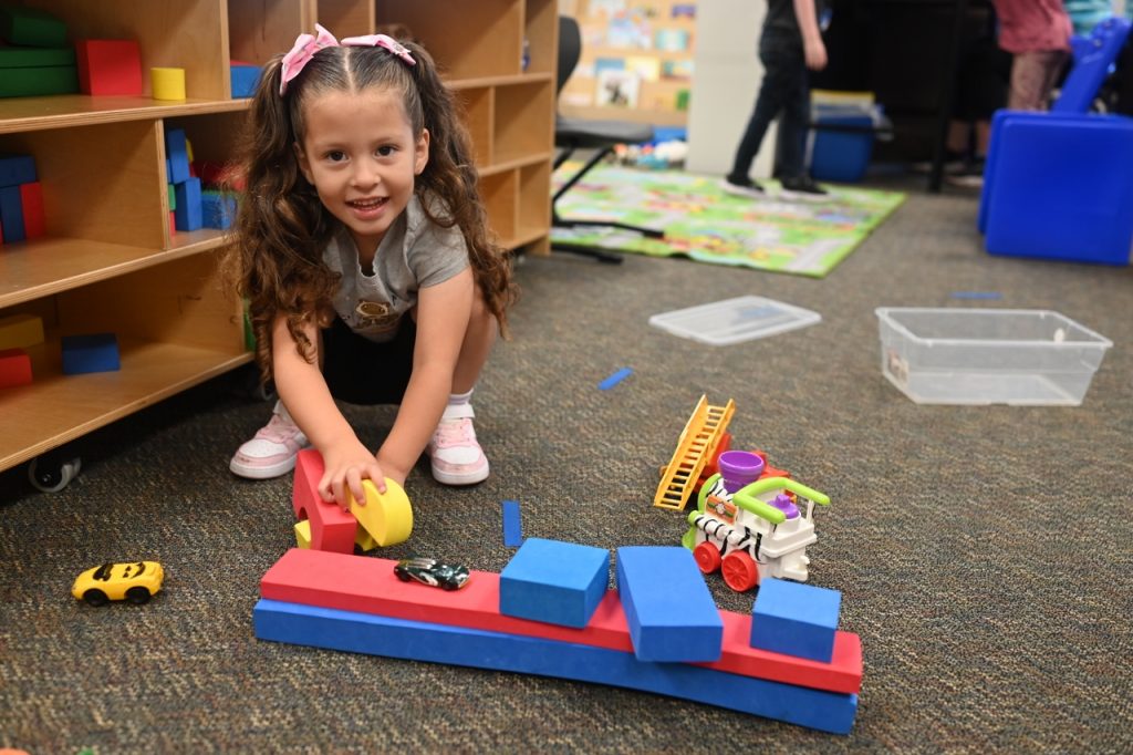 a little girl plays with blocks on the floor
