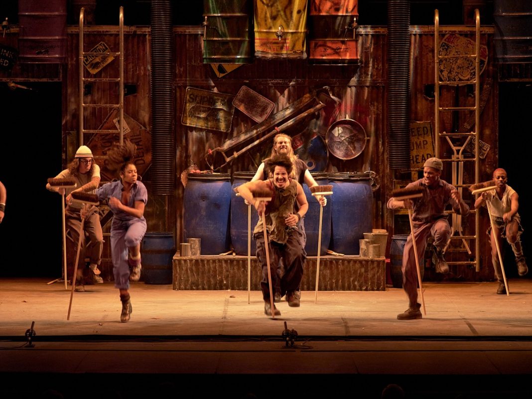STOMP performing on stage with broomsticks