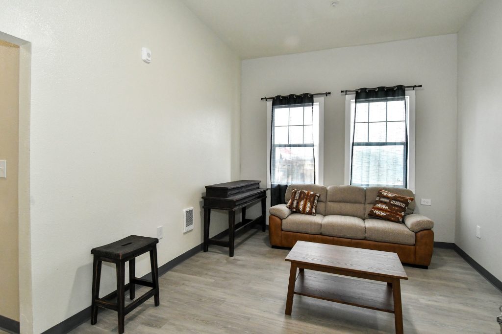 a living room with a couch, coffee table and two side tables.