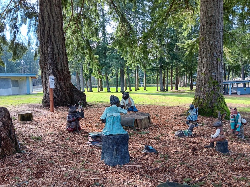 huge evergreen trees surround animal sculptures in LBA park.