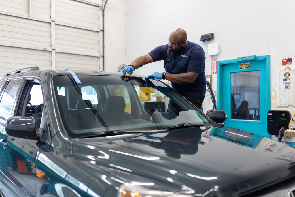 man working on a car windshield