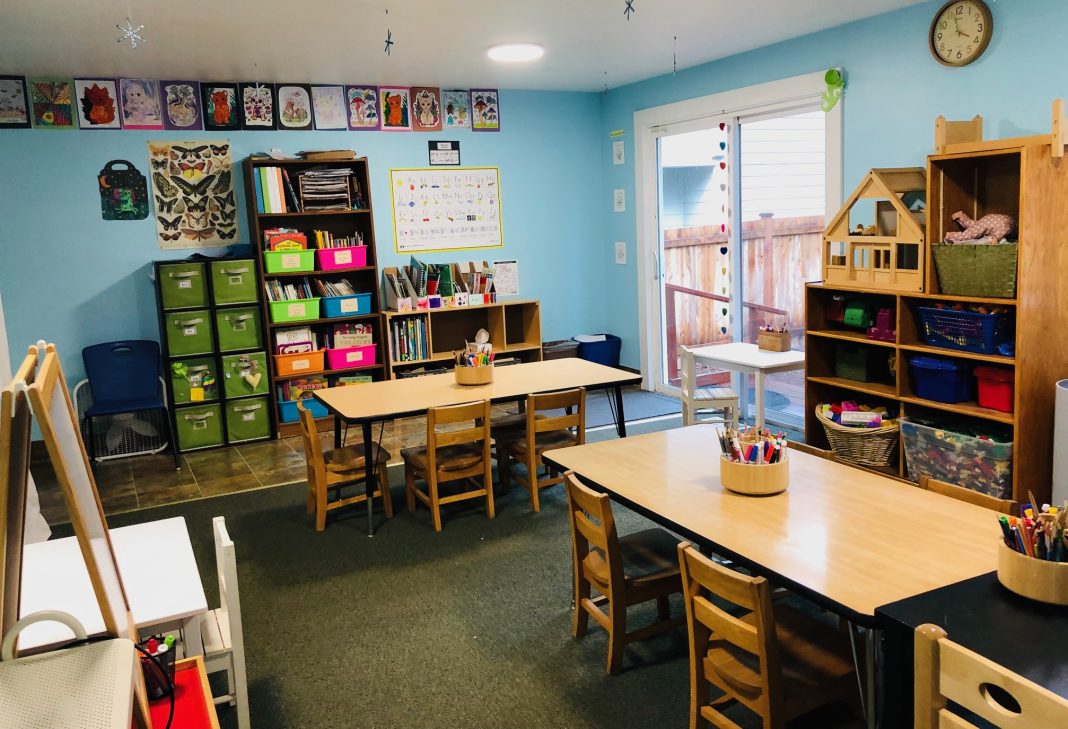 a classroom with tables and chairs at Olympia Community School