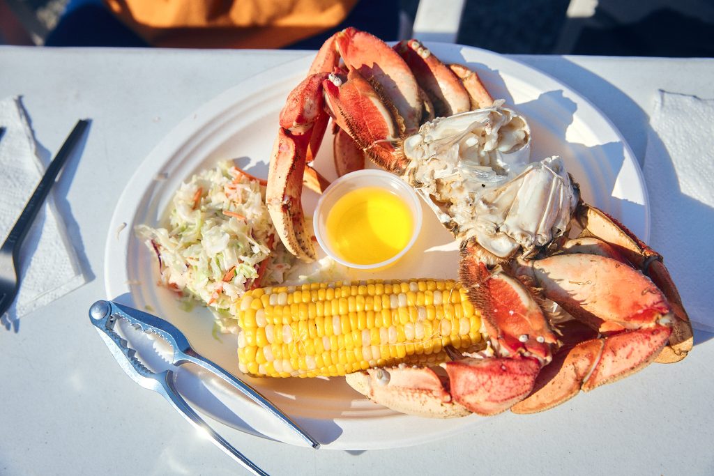 a plate with a crab, corn and potatoes on it