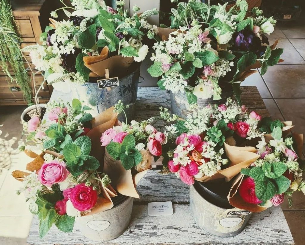 four displays of flowers on a wooden table