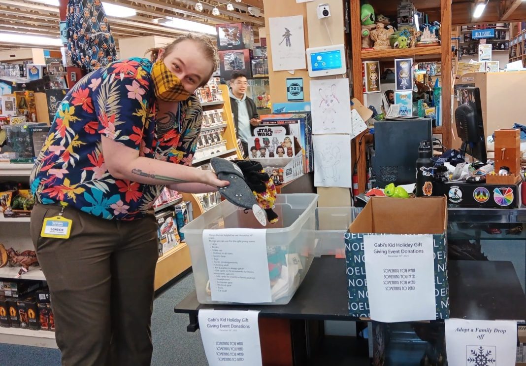 a man in a COVID face mask, puts hats in a donation bin