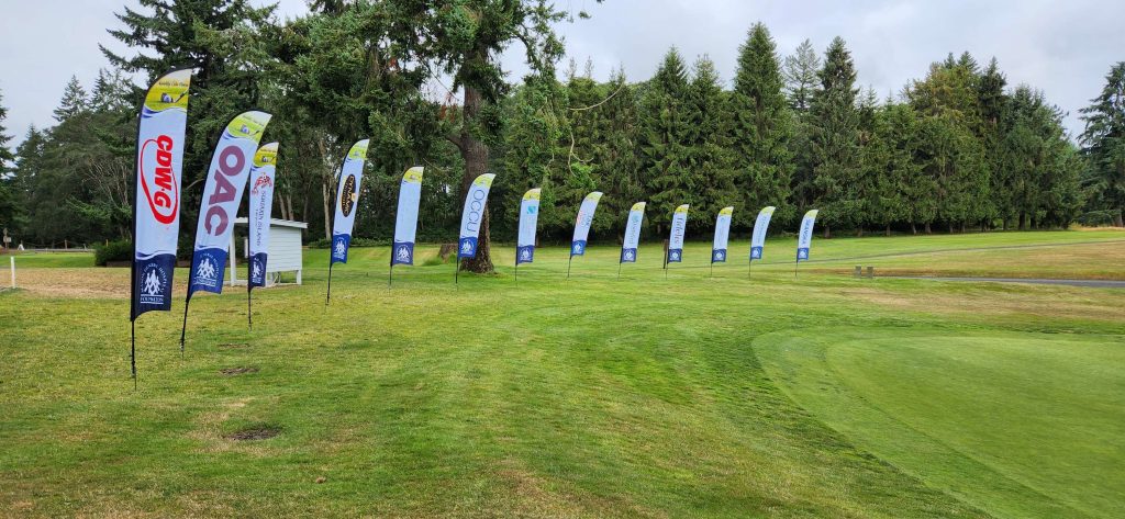 many large sponsor banners on a golf course with different sponsor names on them