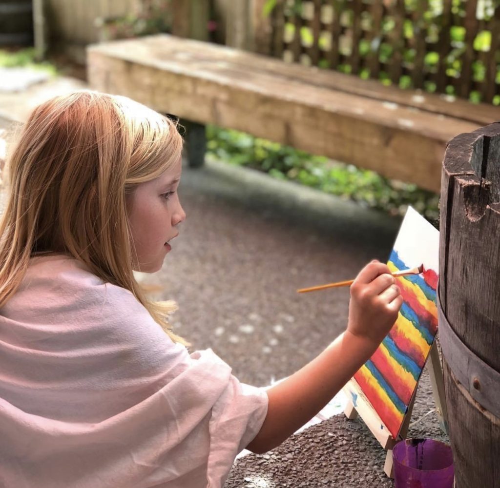 girl sitting outside painting