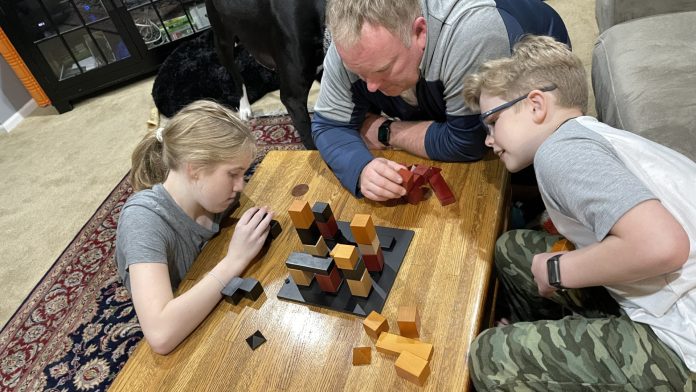 an adult plays with blocks with two kids