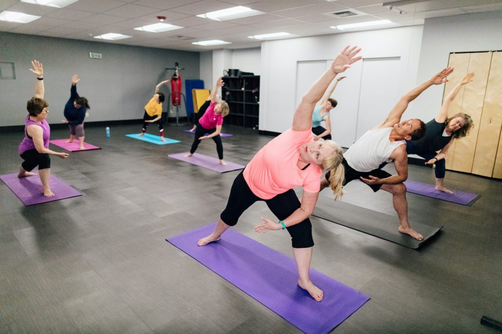 people standing on yoga mats, stretching