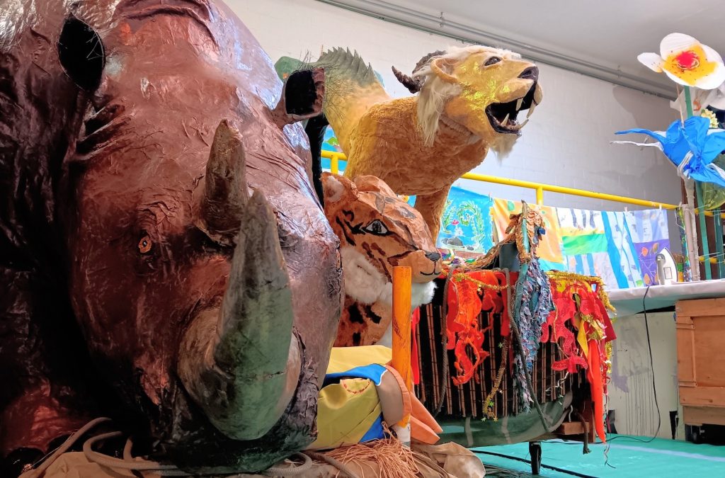 collection of paper mache animals for the Procession of the Species in Olympia including a rhino, tiger and a mythical beast with a lion head and a fish tail