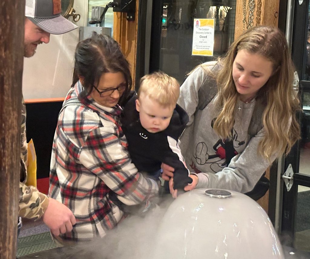 a family looks at a fog fountain