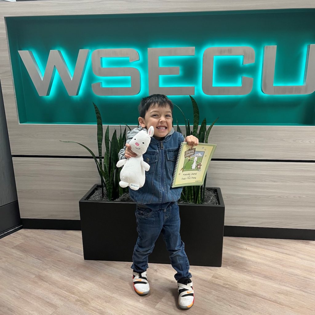 little boy holding a white rabbit stuffed animal and a piece of paper