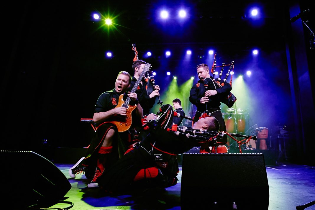 The Red Hot Chilli Pipers performing on stage with smoke and lights