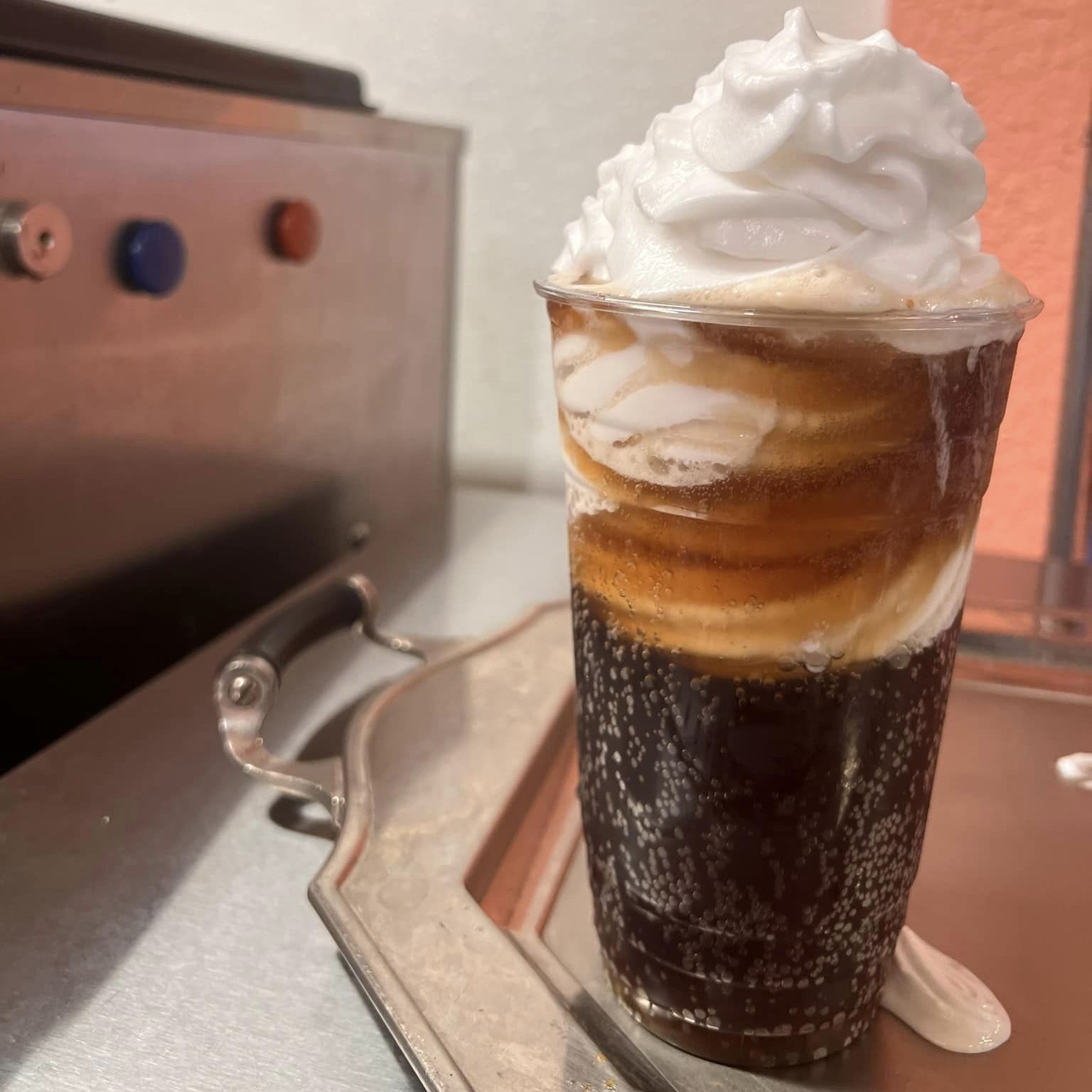 a vegan root beer float with vegan soft serve on top sitting on a counter.