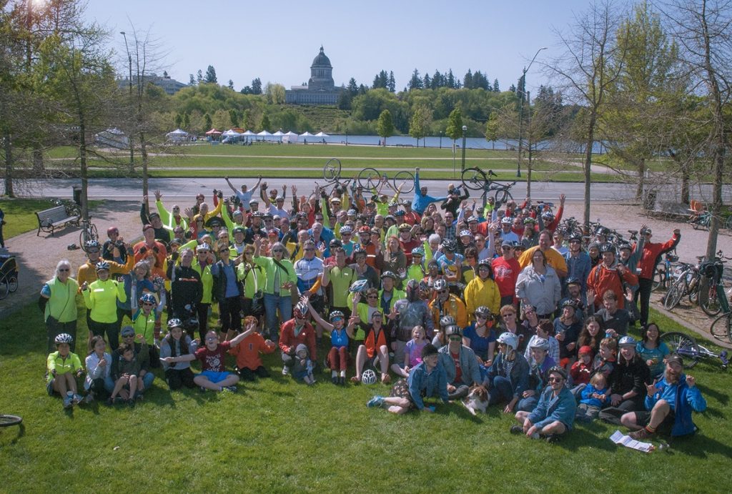 a large group of people posed for a photo with their bikes