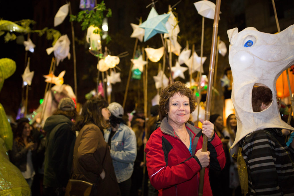 People holding sticks with luminaries attached for the Luminary Procession