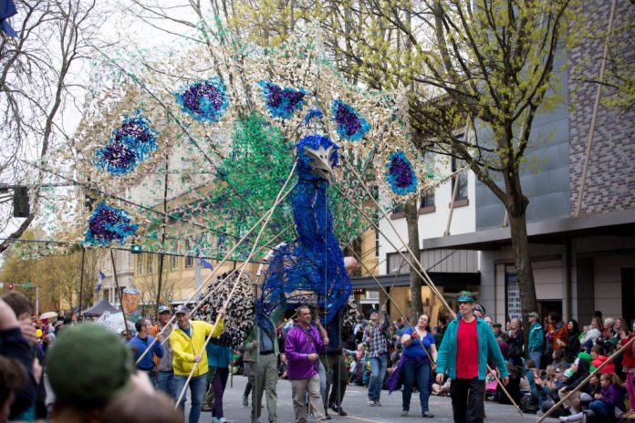 People with a giant peacock 'float' for Olympia's Procession of the species