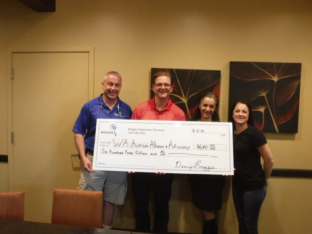 four people hold up a large check