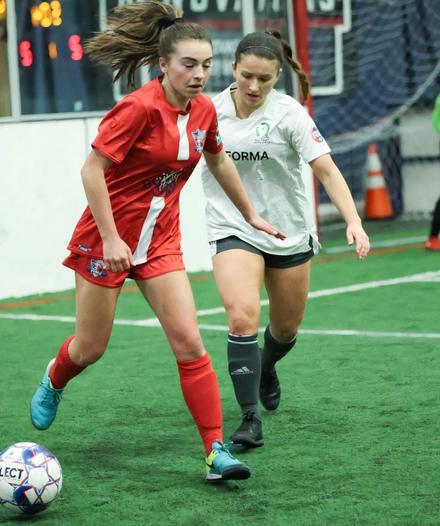 women soccer players playing indoor soccer