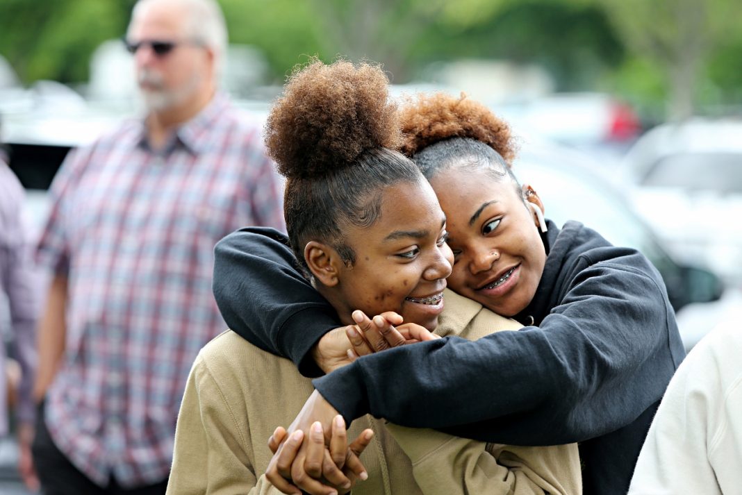 two Black women hugging each other.