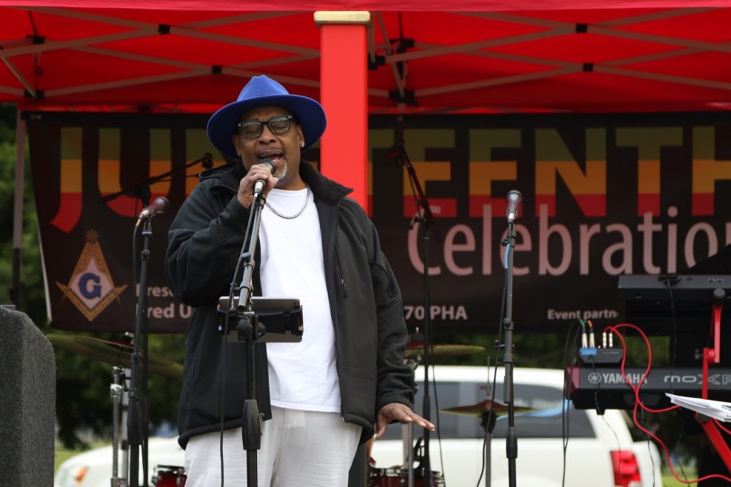 a  Black person on a stage speaking into a microphone