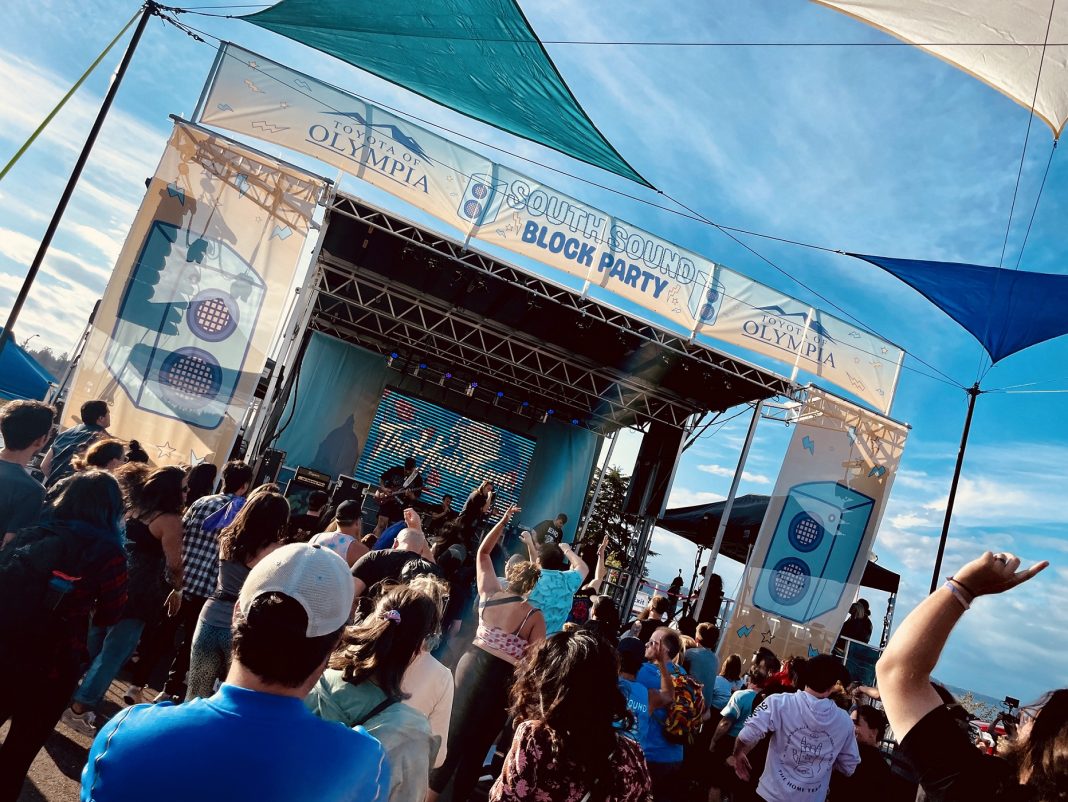 large group of people listening to music on an outdoor stage