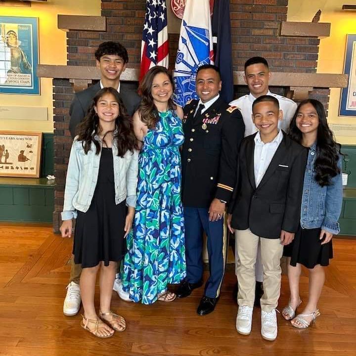 Dr. Jennifer Thomas with her family standing in front of a US flag