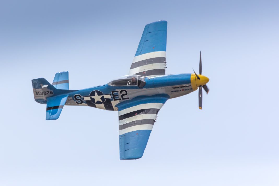 vintage plane with red white and blue stripes flying