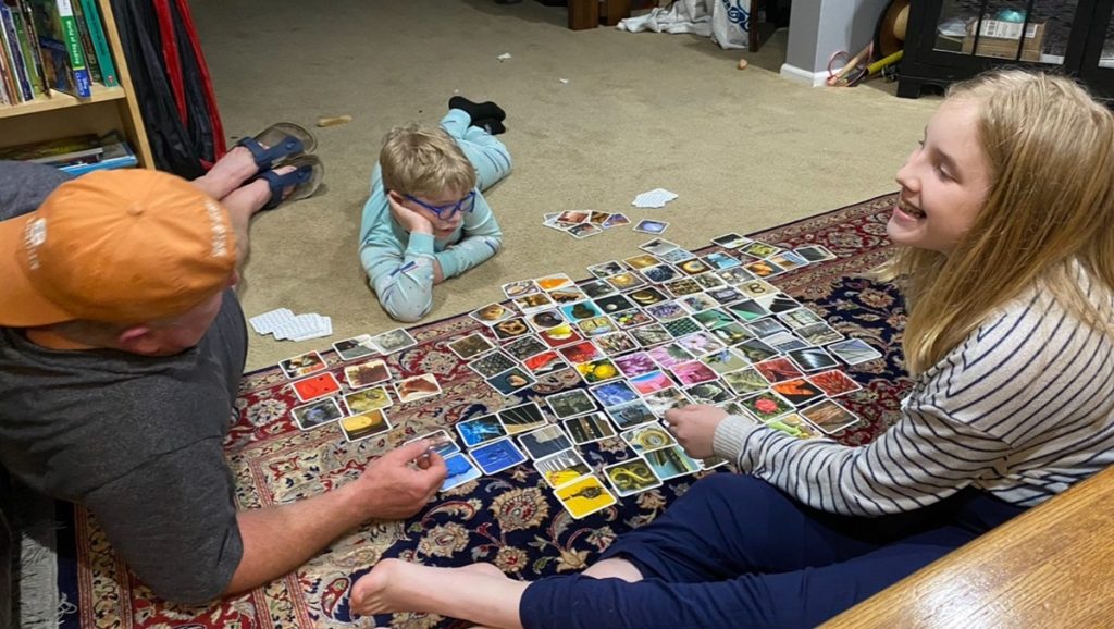 parents and kids on the floor playing a card game