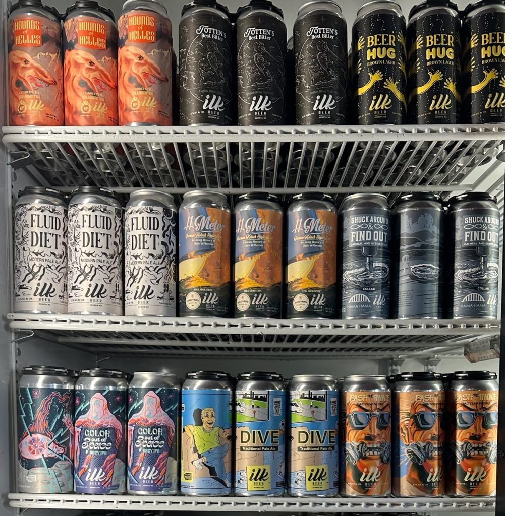 a refrigerator case with canned beer on three shelves