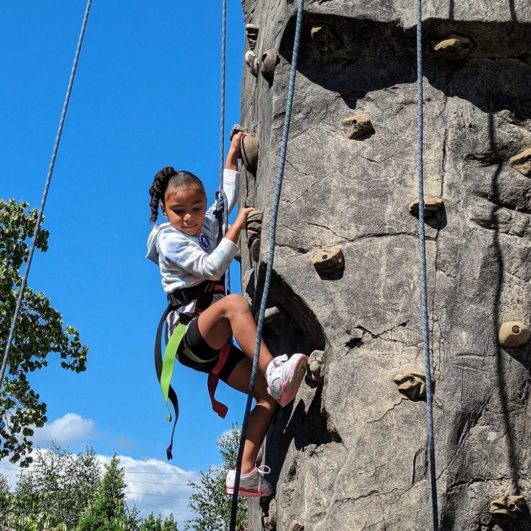 a little girl on the climbing rock wall at Hands on Children's Museum