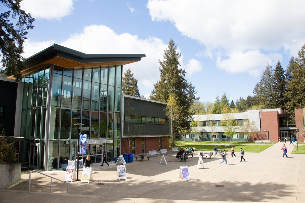 South Puget Sound Community College campus building with kids walking through a courtyard. Lots of A frame signs are in the courtyard.