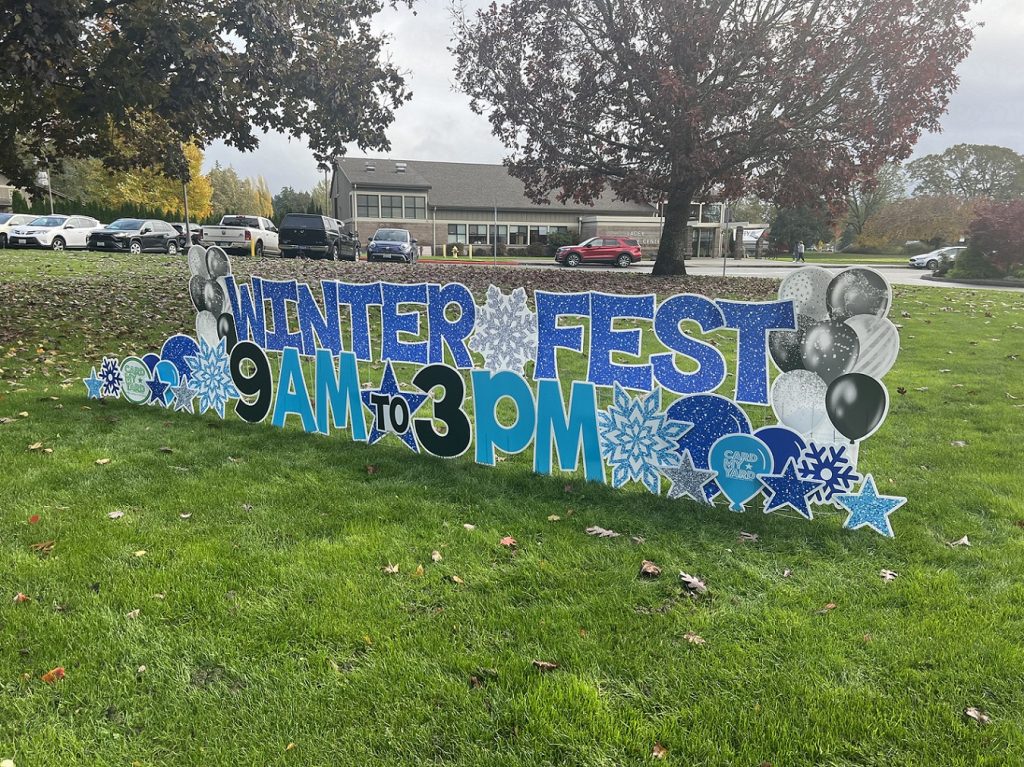 a cut out sign on a lawn that says 'Winter Fest 9 am to 3 p.m.