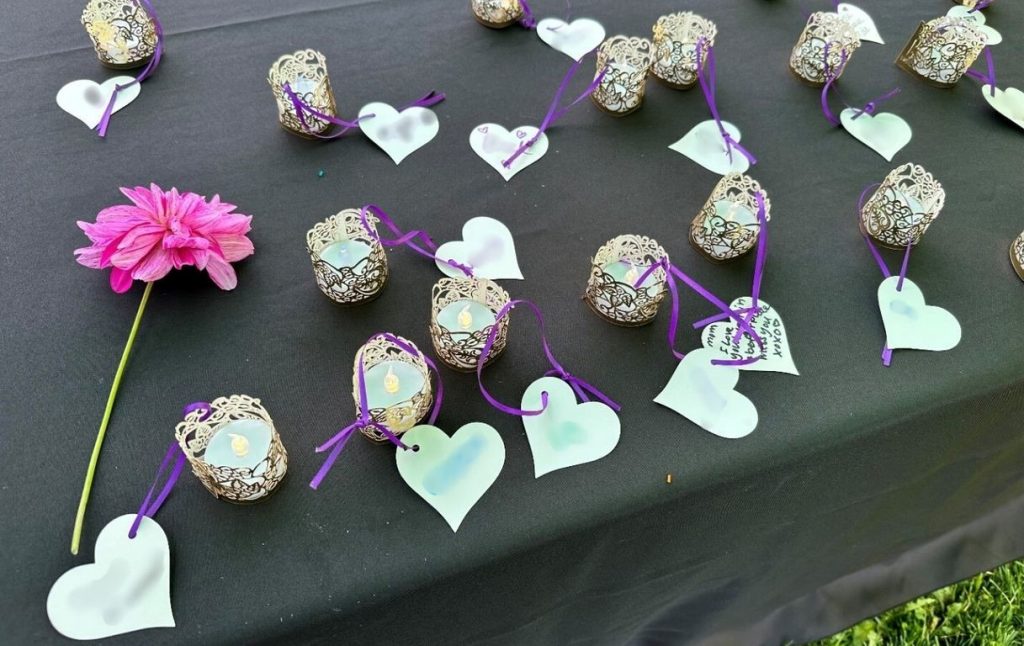 tea lights in holders with paper hearts with names on them attached to the candle holders.