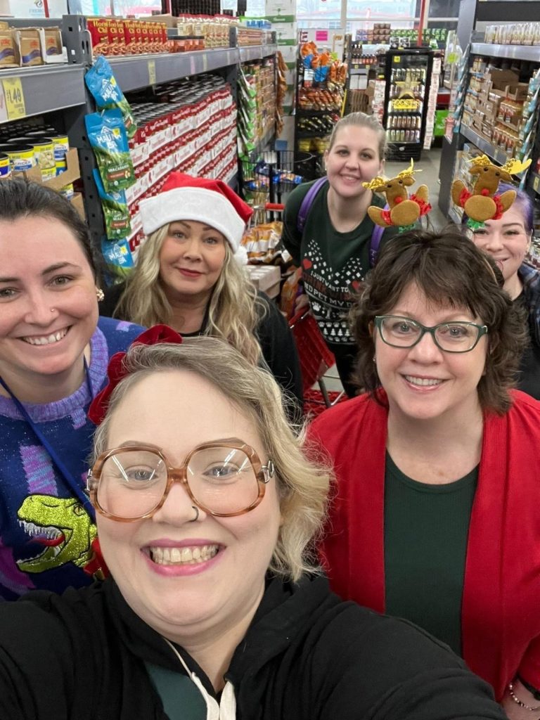 people smiling in a group for a photo at a grocery store
