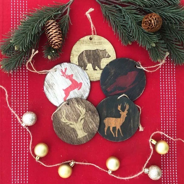 wood ornaments on a red background with deer, birds and bears o them