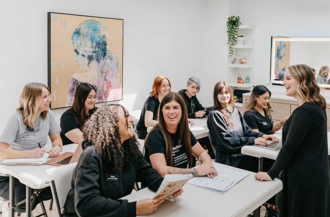 women sitting at tables with a teacher in front of them